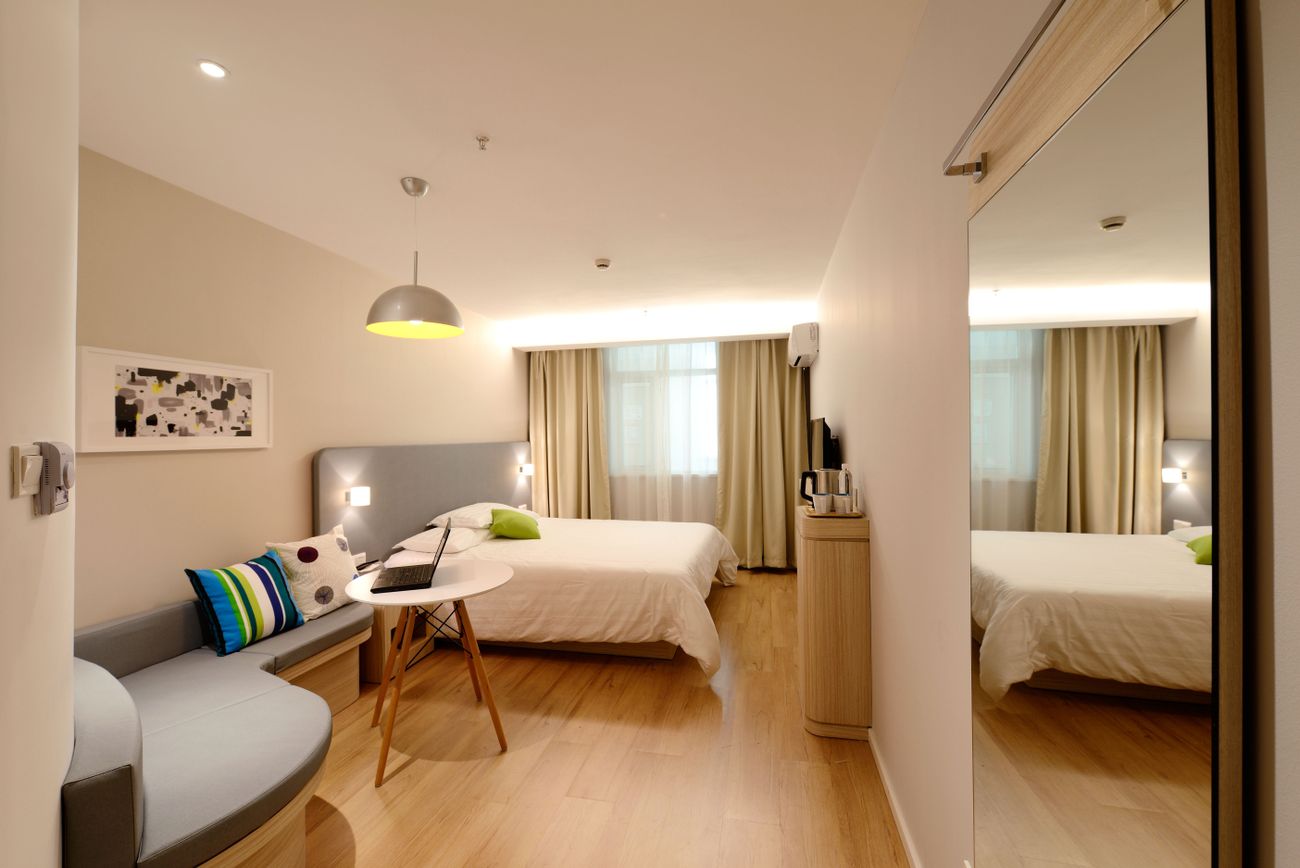 Helles Hotelzimmer mit großem Bett und Sitzbereich
